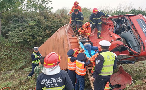 大貨車沖出高速護欄側(cè)翻 司機被困